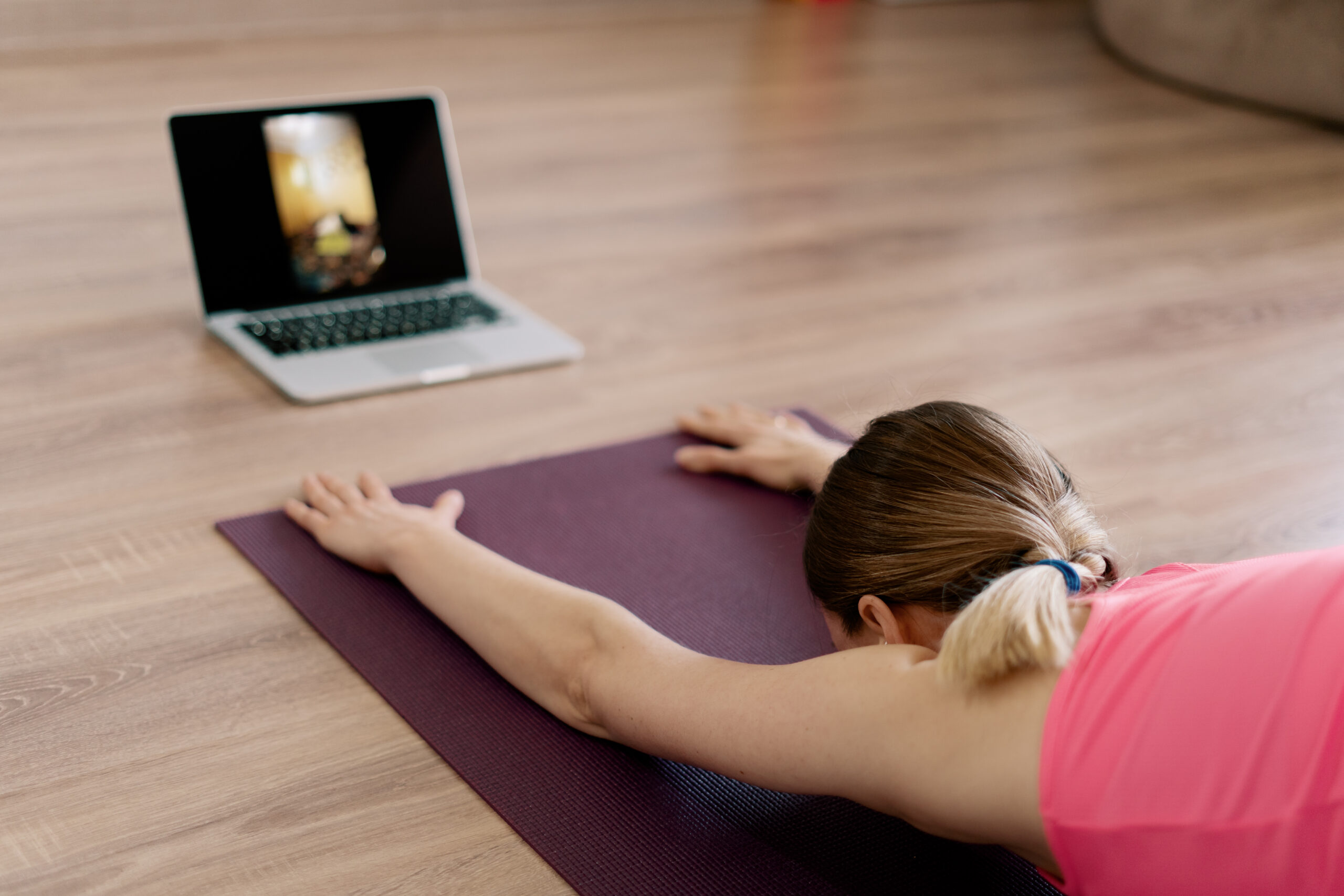 Attractive woman practicing yoga at home using online training instructions